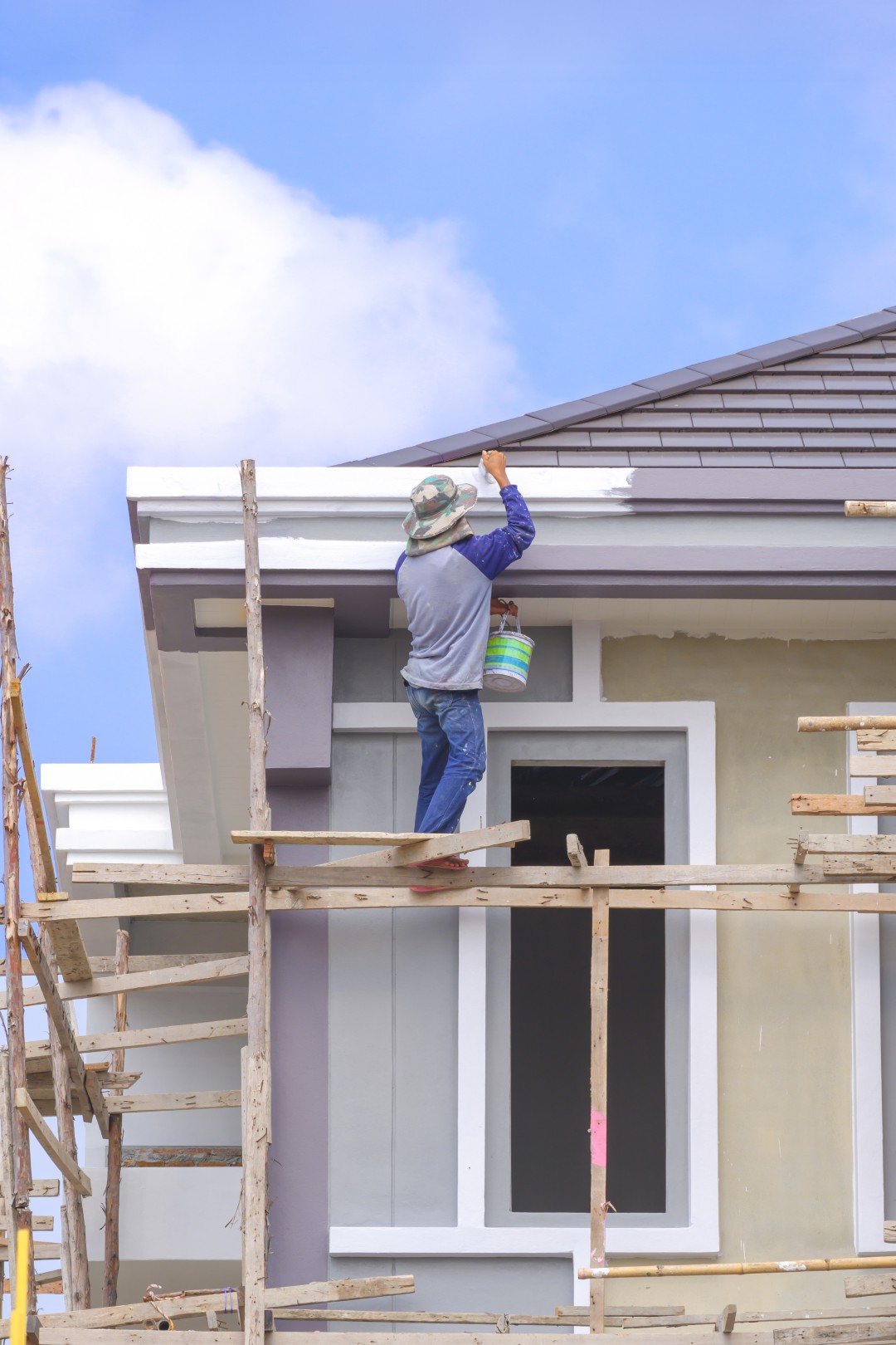 painter-wooden-scaffolding-is-painting-roof-eaves-modern-house-structure-construction-site (Large)